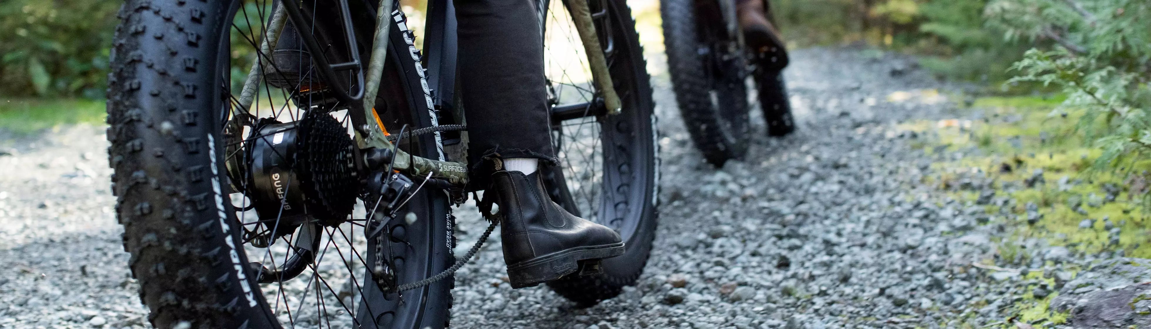 Person riding Surface 604 Fat Tire eBike on gravel path 